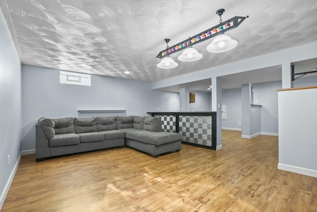 living room featuring baseboards, bar area, and wood finished floors