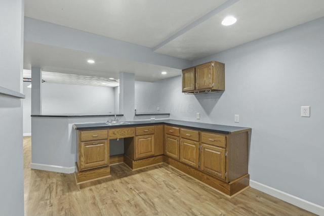 kitchen with dark countertops, brown cabinets, and light wood-type flooring