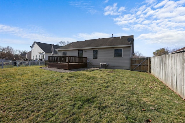 rear view of house with central air condition unit, a yard, a fenced backyard, and a wooden deck