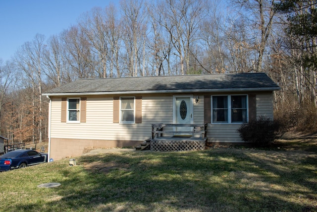 ranch-style home with a front lawn and roof with shingles