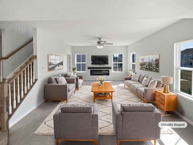 living room featuring baseboards, stairs, and ceiling fan