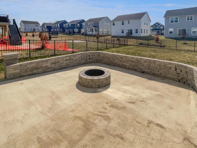 view of patio / terrace with a fire pit, a residential view, and a fenced backyard