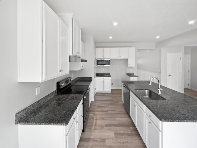 kitchen with a center island with sink, recessed lighting, white cabinets, stainless steel appliances, and a sink