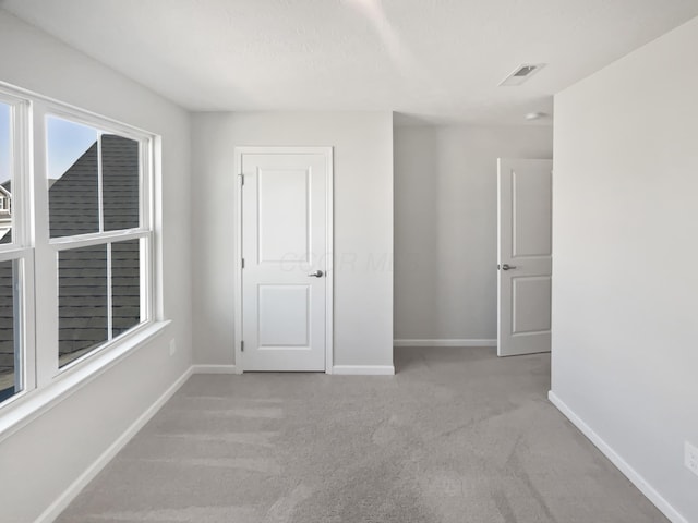 empty room with carpet flooring, baseboards, and visible vents