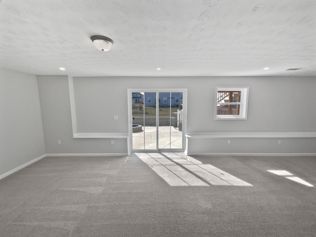 carpeted spare room featuring recessed lighting, baseboards, and a textured ceiling