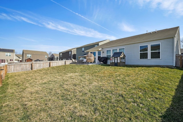 back of property with a residential view, a lawn, and a fenced backyard