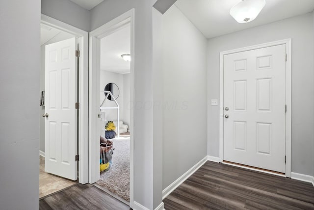 entryway with dark wood finished floors and baseboards