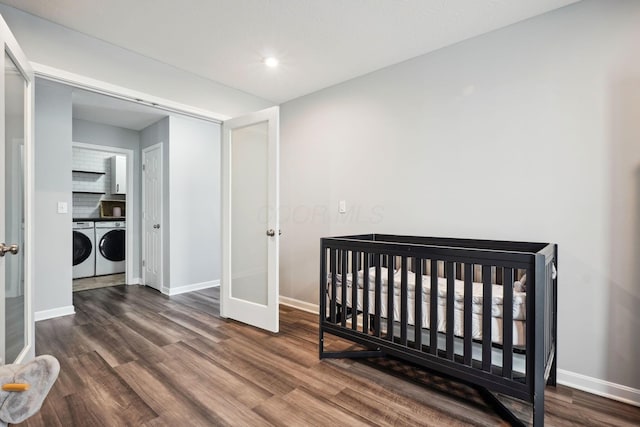 bedroom with independent washer and dryer, french doors, and wood finished floors