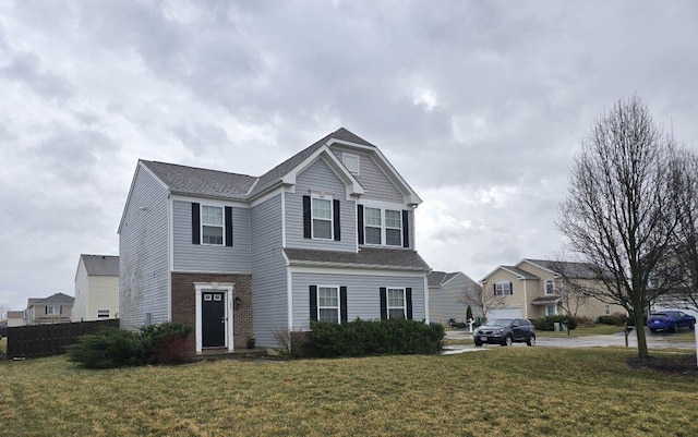 view of front of property featuring a front lawn, fence, and brick siding