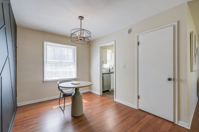 dining space featuring a notable chandelier, wood finished floors, and baseboards