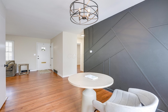 sitting room featuring visible vents, baseboards, a notable chandelier, and light wood-style flooring