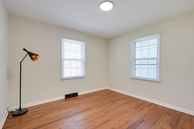 unfurnished room featuring baseboards and wood finished floors