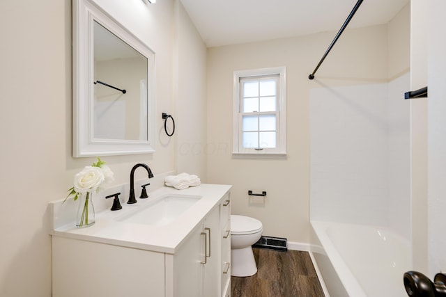 full bathroom with toilet, wood finished floors, baseboards, bathtub / shower combination, and vanity