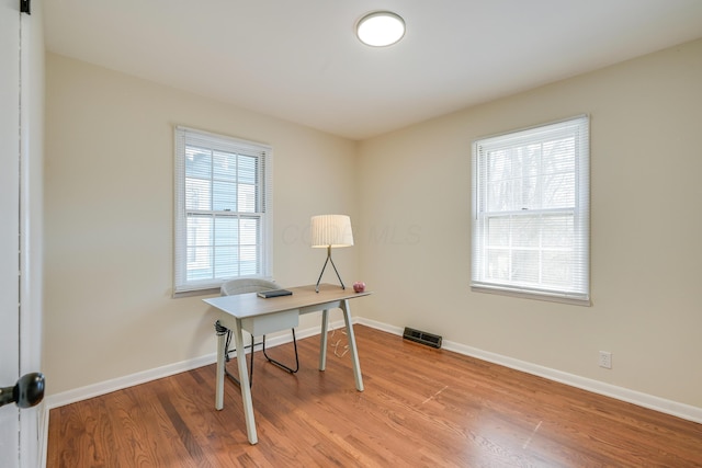 office featuring visible vents, baseboards, and light wood-style flooring