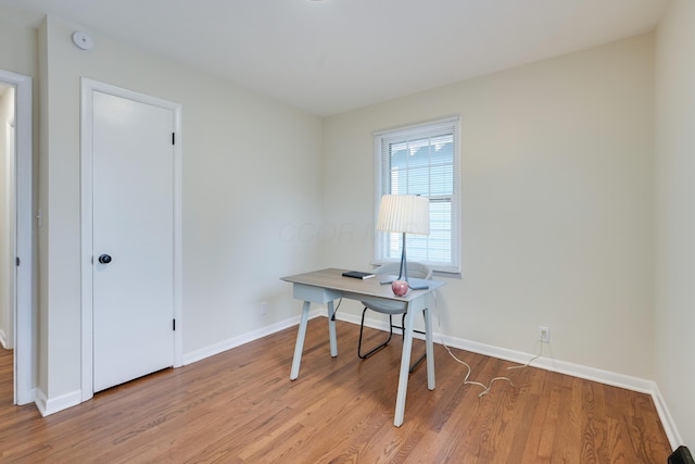 office space featuring light wood-type flooring and baseboards