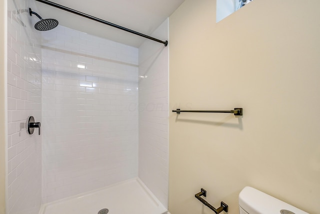 full bathroom featuring toilet and tiled shower