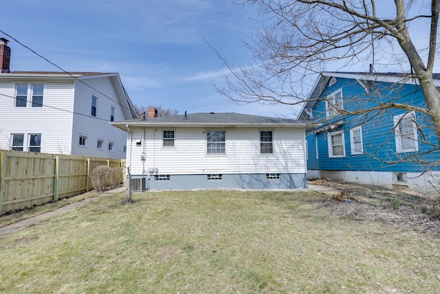 rear view of property with central air condition unit, a lawn, a chimney, and fence