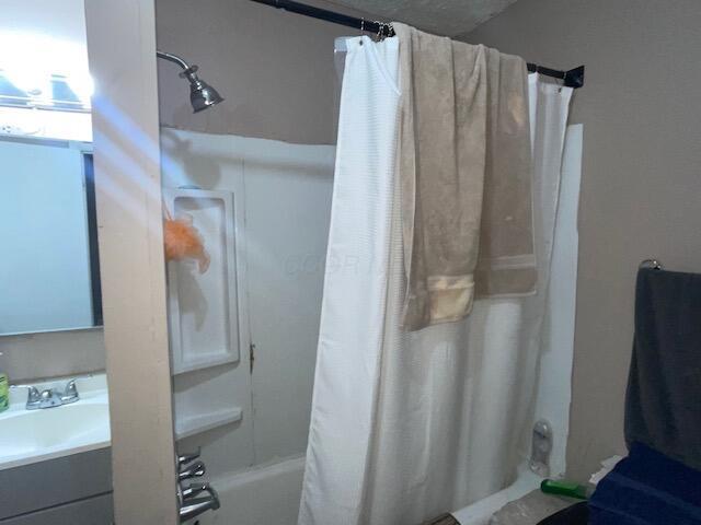 bathroom featuring shower / bath combo and vanity