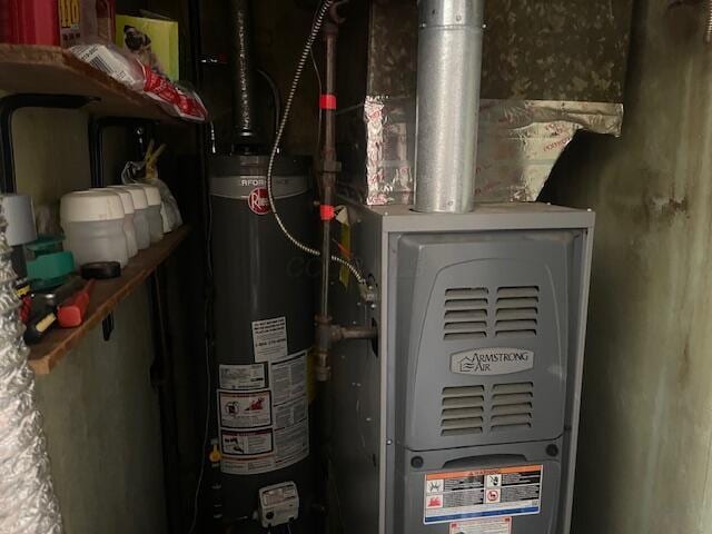 utility room featuring heating unit and gas water heater