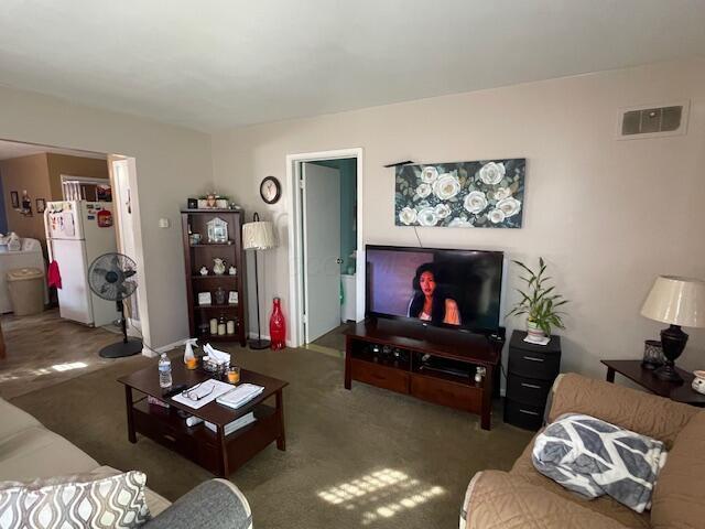 carpeted living room featuring visible vents