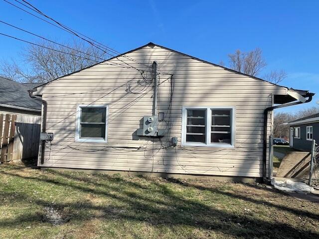 view of home's exterior with a yard and fence