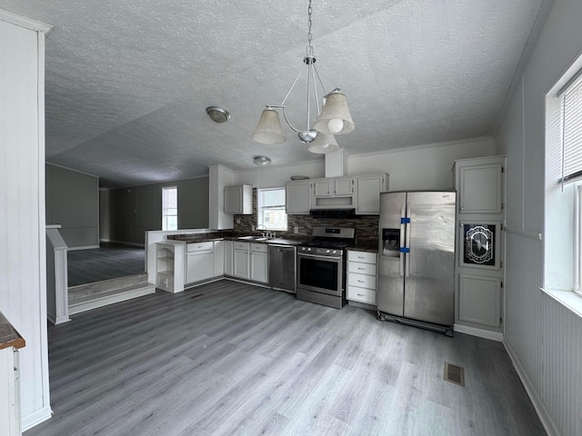 kitchen featuring dark countertops, visible vents, light wood-style flooring, and appliances with stainless steel finishes