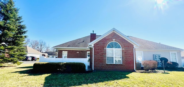 view of home's exterior with brick siding, a lawn, and a chimney