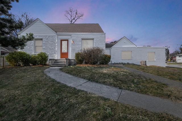 view of front facade featuring stone siding and a yard