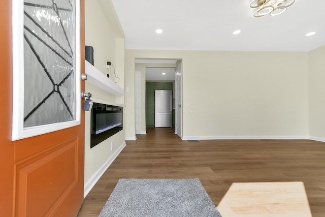 interior space featuring recessed lighting, baseboards, wood finished floors, and freestanding refrigerator