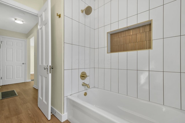 full bath featuring baseboards, shower / washtub combination, and wood finished floors