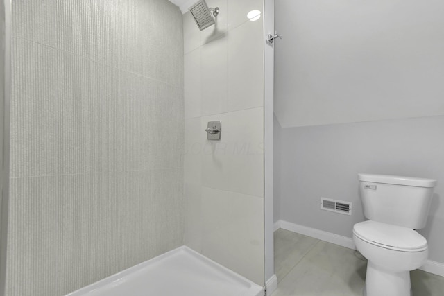 bathroom featuring visible vents, tiled shower, toilet, and baseboards