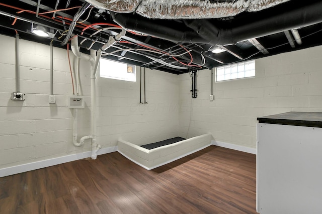 basement with dark wood finished floors, fridge, and plenty of natural light