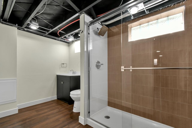 bathroom featuring vanity, a shower stall, wood finished floors, and baseboards