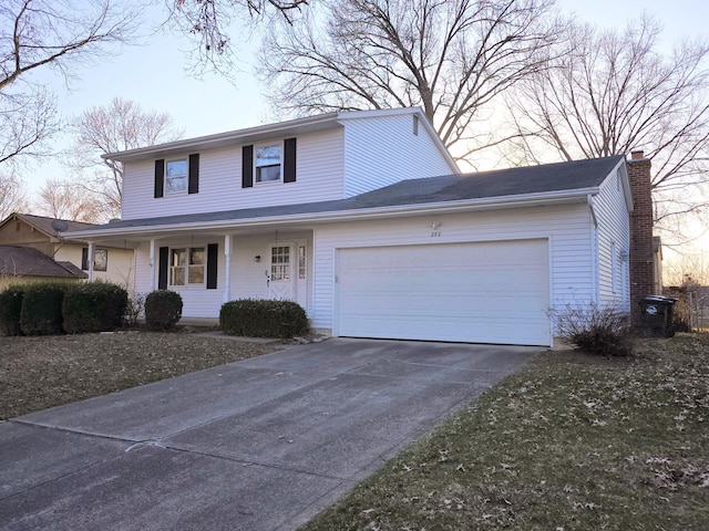 traditional-style house featuring a garage, a porch, concrete driveway, and a chimney