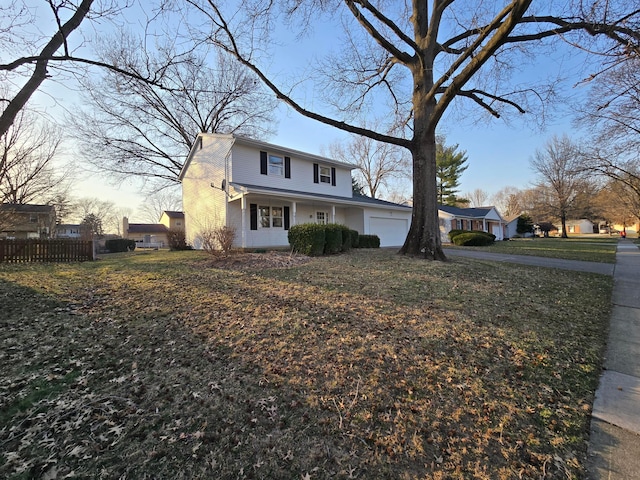 traditional-style house featuring an attached garage, driveway, and fence