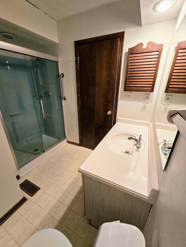 full bathroom featuring vanity, toilet, a shower stall, and a textured ceiling