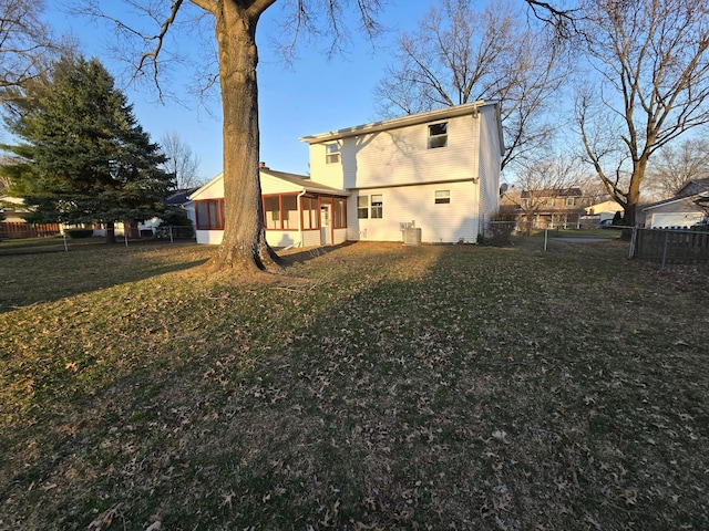 back of house with a yard, fence, and a sunroom