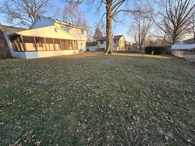 view of yard with fence and a sunroom