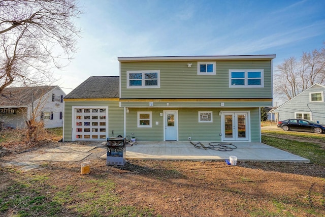 back of house featuring a patio area, an attached garage, and french doors