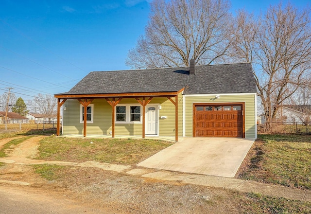 view of front of home with driveway, fence, roof with shingles, a garage, and a chimney