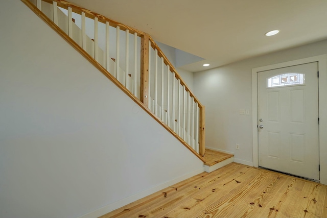 foyer entrance featuring recessed lighting, baseboards, wood finished floors, and stairs