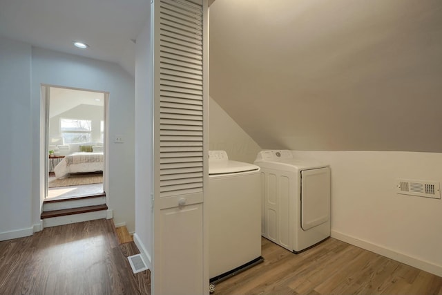 laundry room with light wood finished floors, visible vents, independent washer and dryer, and baseboards