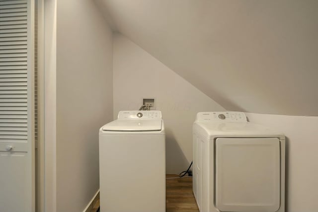 laundry room featuring separate washer and dryer, wood finished floors, and laundry area