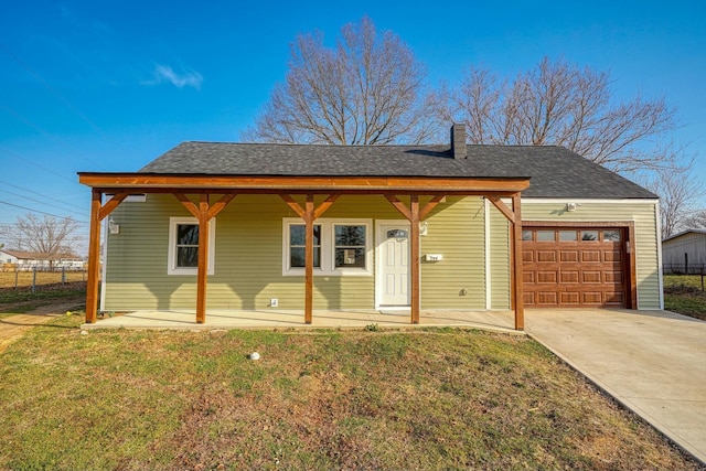 view of front of home with a garage, a shingled roof, a front yard, and fence