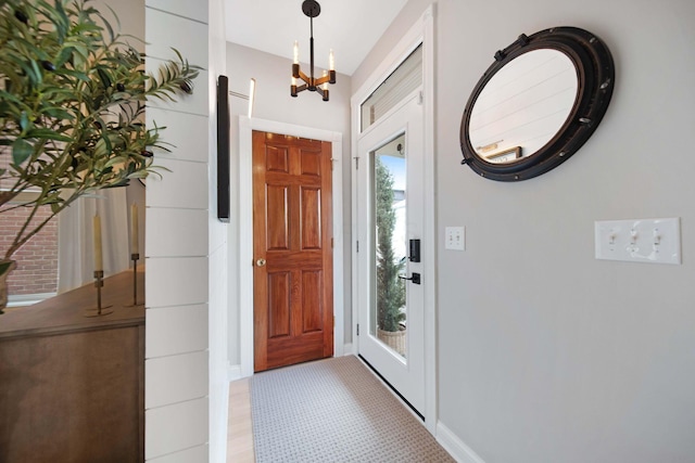 foyer entrance featuring baseboards and a notable chandelier