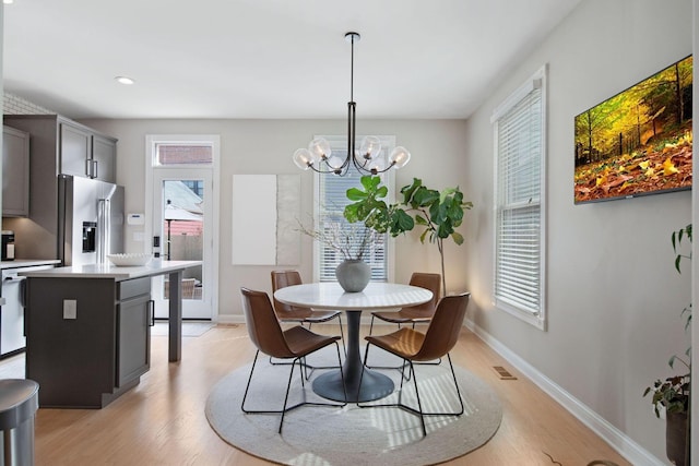 dining room featuring visible vents, baseboards, light wood-style flooring, recessed lighting, and a notable chandelier