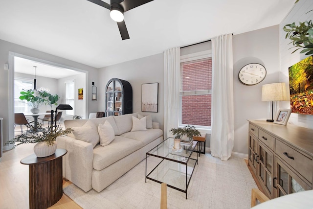 living room featuring baseboards and ceiling fan