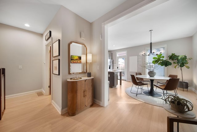 hall with recessed lighting, baseboards, an inviting chandelier, and light wood-style flooring