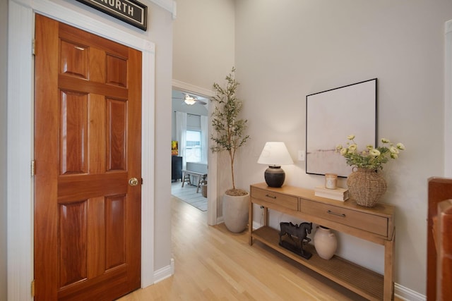 foyer with baseboards and light wood-style flooring