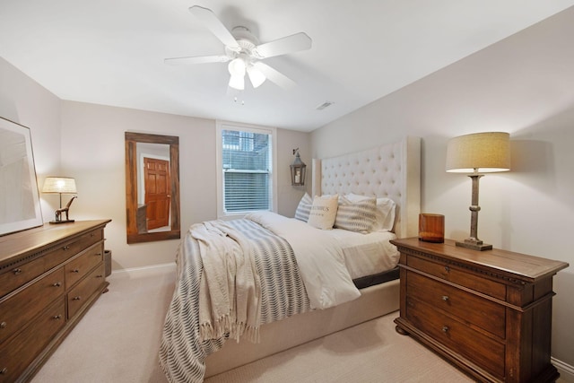 bedroom featuring visible vents, light colored carpet, baseboards, and a ceiling fan